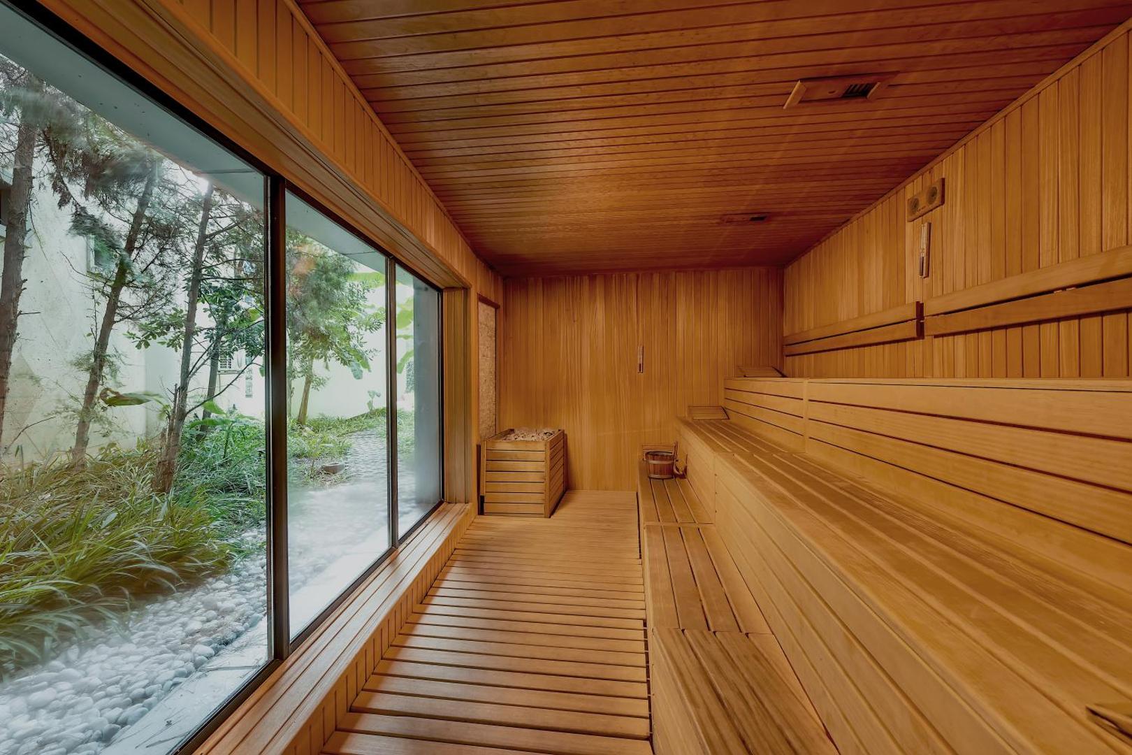 Paloma Sencia viesnīcas sauna ar koka lāvām un lielu panorāmas logu ar skatu uz dārzu, Beleka