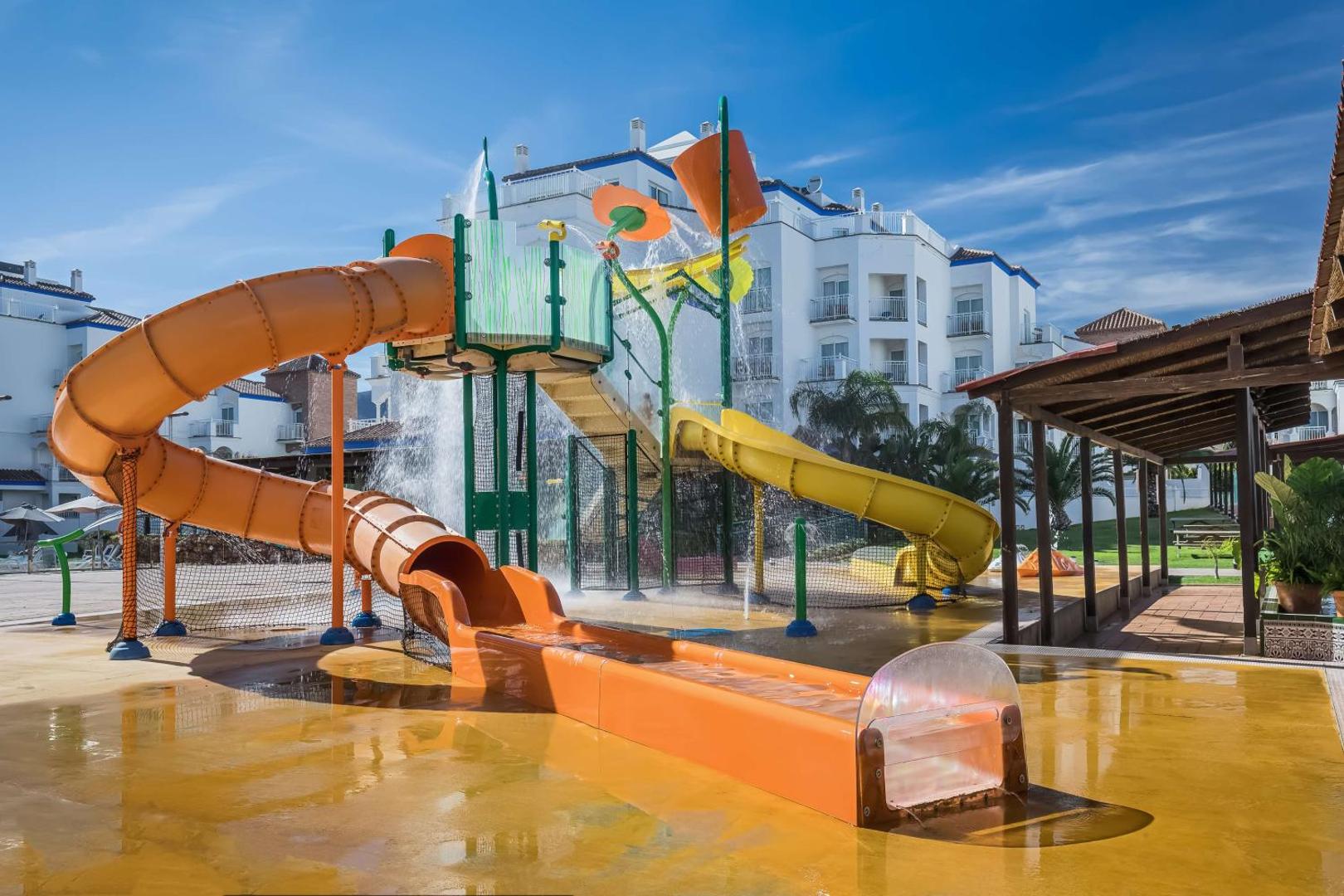Occidental Torremolinos Playa bērnu ūdens atrakciju parks ar krāsainiem slidkalniņiem un ūdens spaiņiem saulainā dienā Malagas reģionā