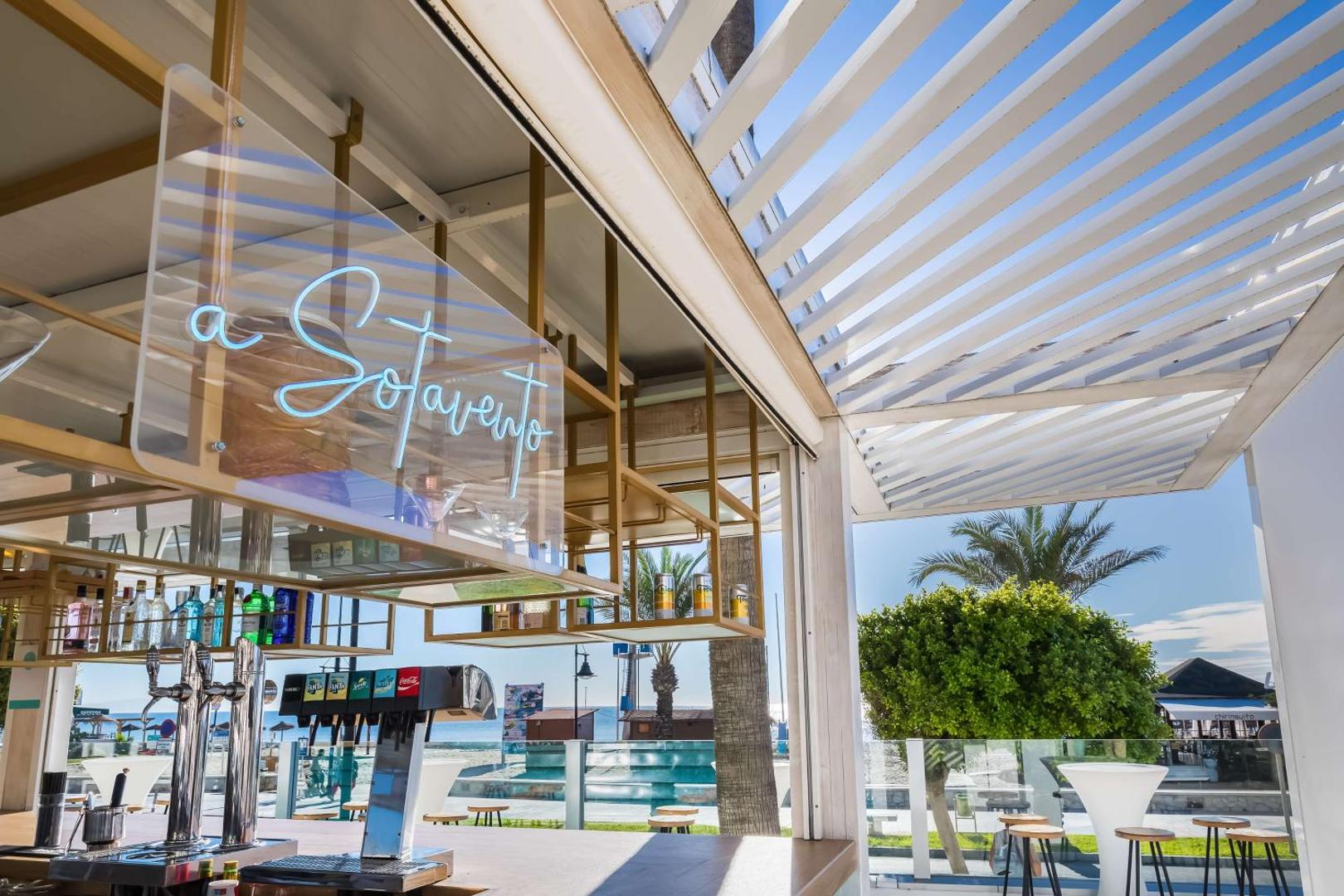 Occidental Torremolinos Playa pludmales bārs Sotavento ar skatu uz palmu dārzu un jūru — dzērienu servēšanas zona piekrastē