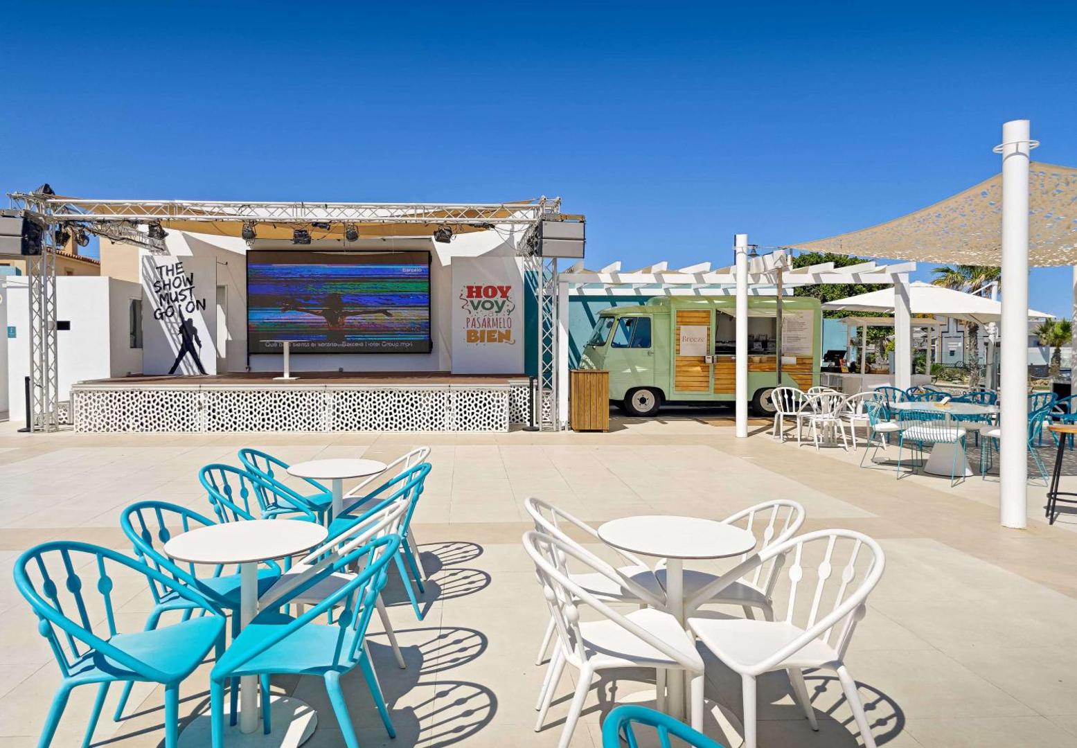 Occidental Torremolinos Playa āra pasākumu zona ar skatuvi, ekrānu un stilīgu Breeze bāra vagoniņu atpūtas terasē