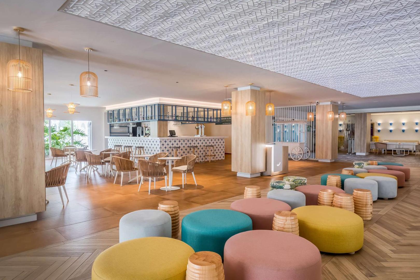 Occidental Torremolinos Playa viesnīcas lobby bārs ar krāsainiem atpūtas krēsliem un stilīgu apgaismojumu — plaša atpūtas zona viesiem