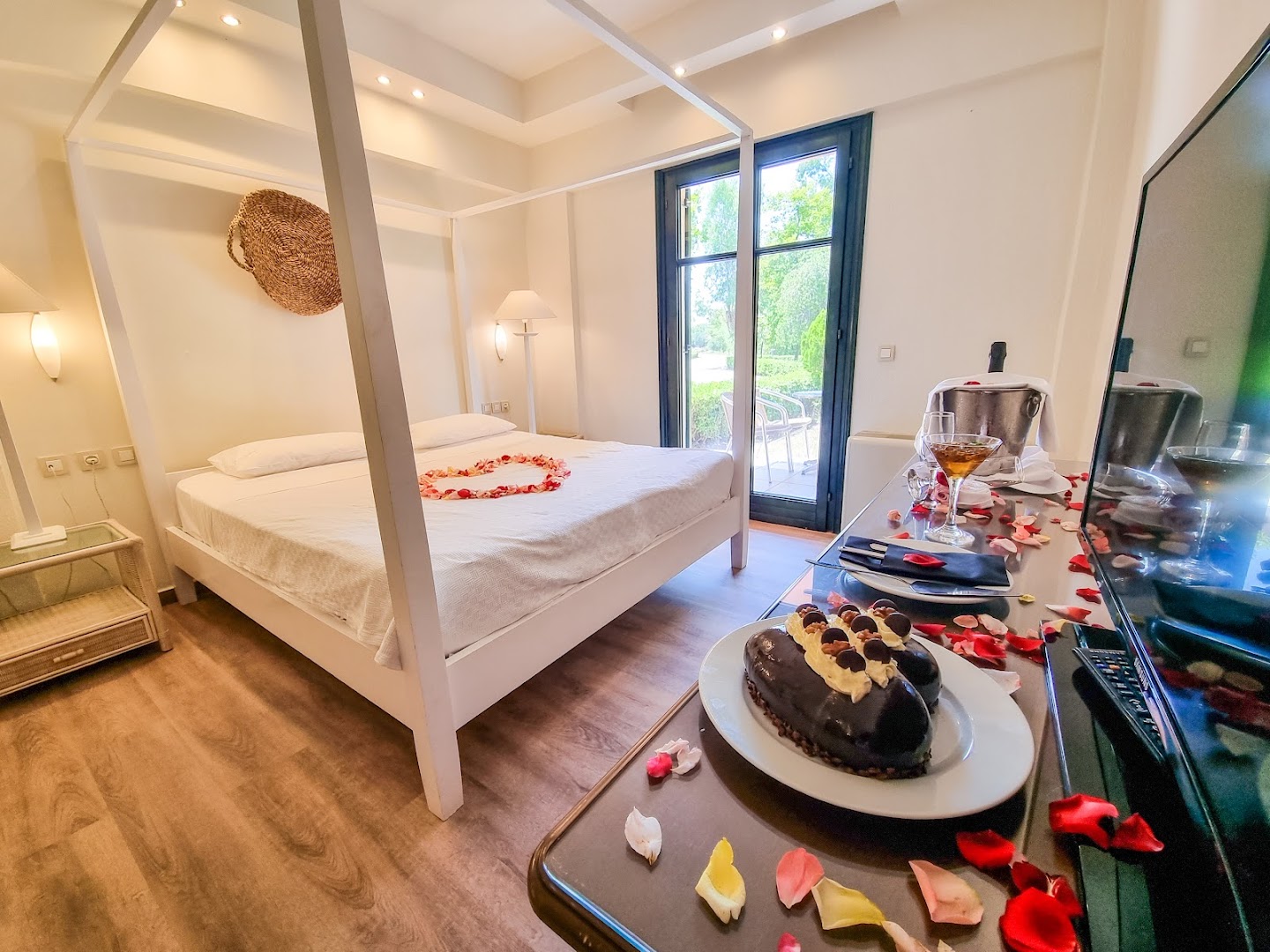 Grecotel Costa Botanica romantiskais numurs ar baldahīna gultu, rožlapiņām, šokolādes kūku un dzērienu Korfu salā, Grieķijā.