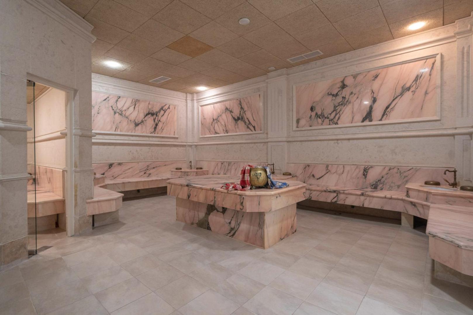 Grifid Hotel Arabella spa centra tradicionālais turku hamams ar rozā marmora apdari, akmens soliem un centrālo masāžas galdu