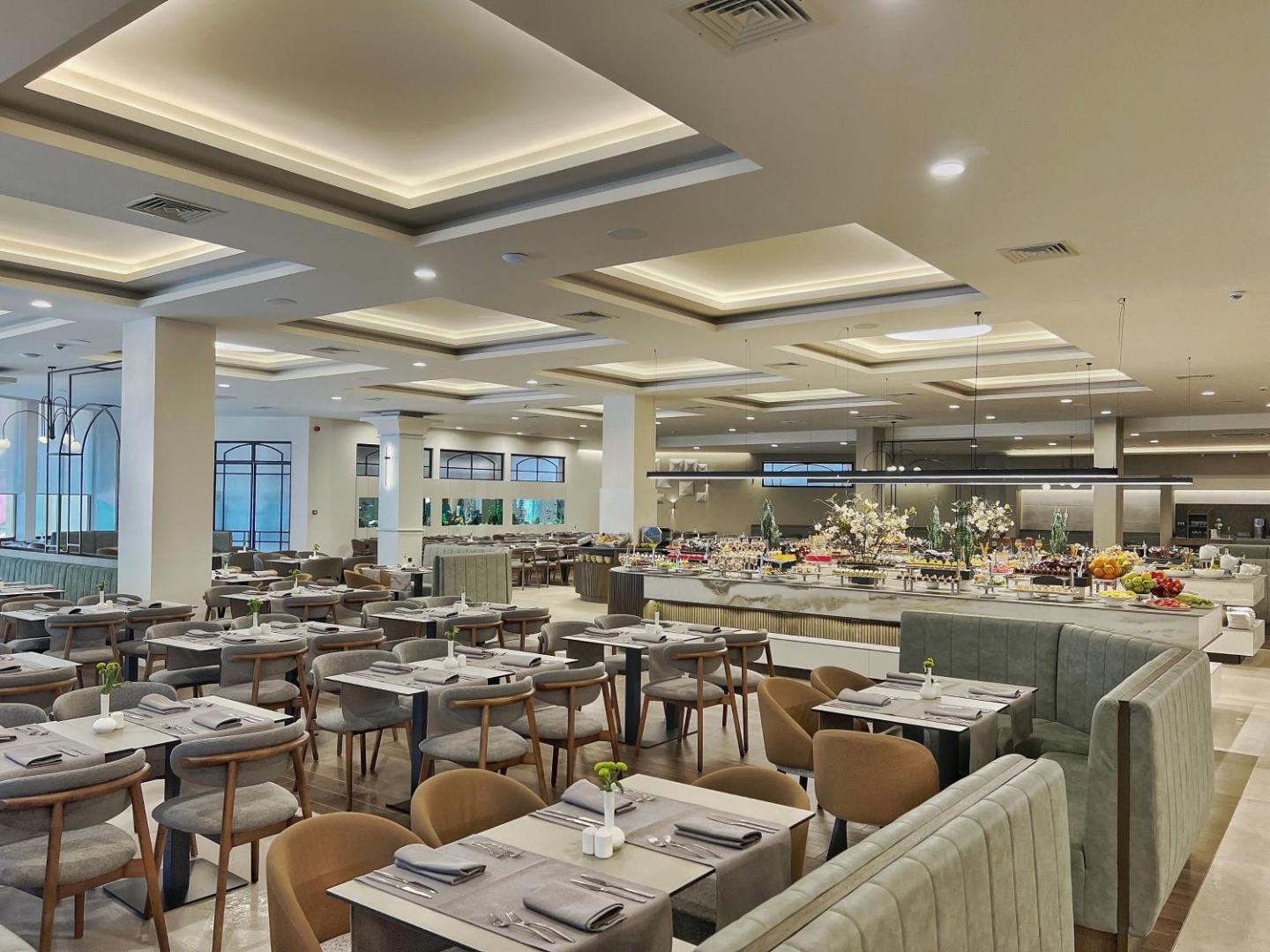 Plašs un gaišs Grifid Club Hotel Bolero galvenais restorāns ar bagātīgu bufetes līniju un modernām mēbelēm