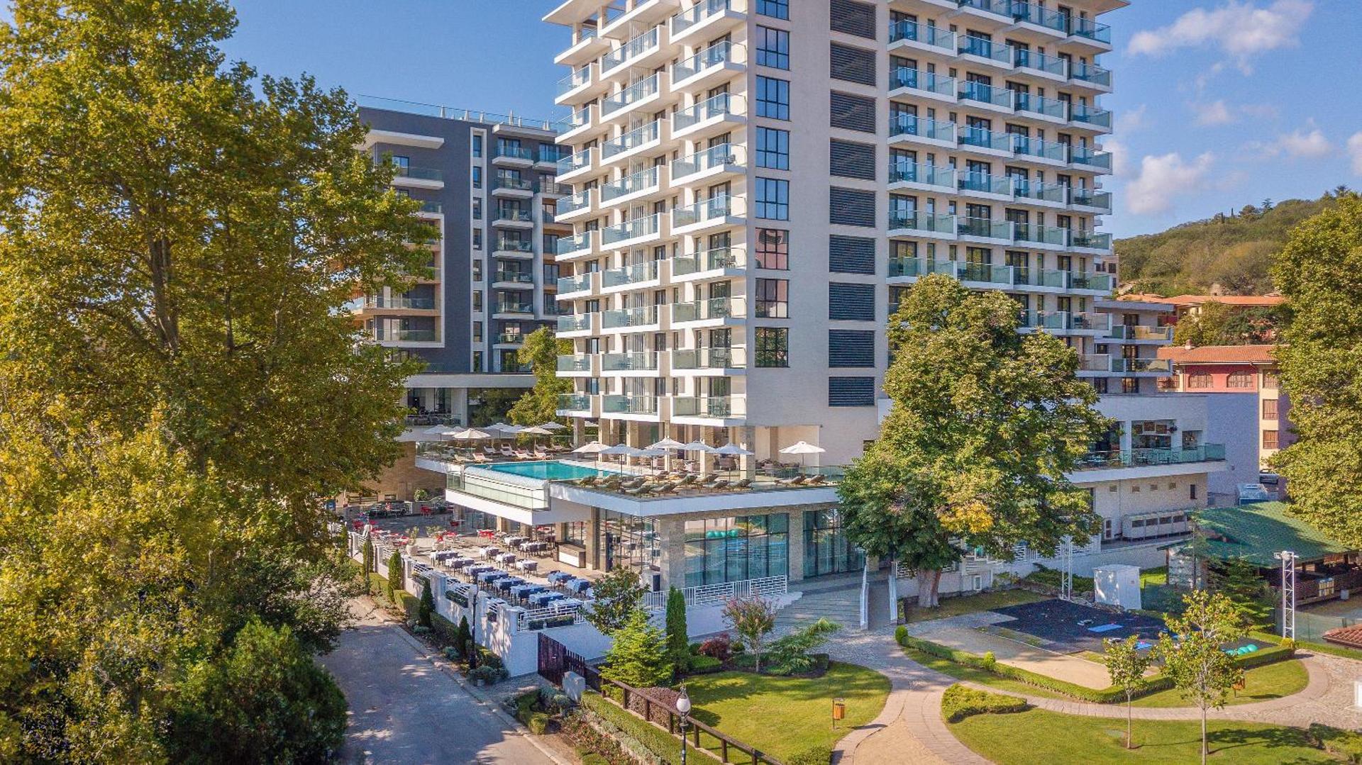 GRIFID Metropol Hotel modernā ēka Zelta Smiltīs, Bulgārijā — skats uz fasādi, āra terasi ar restorānu un labiekārtotu zaļo zonu
