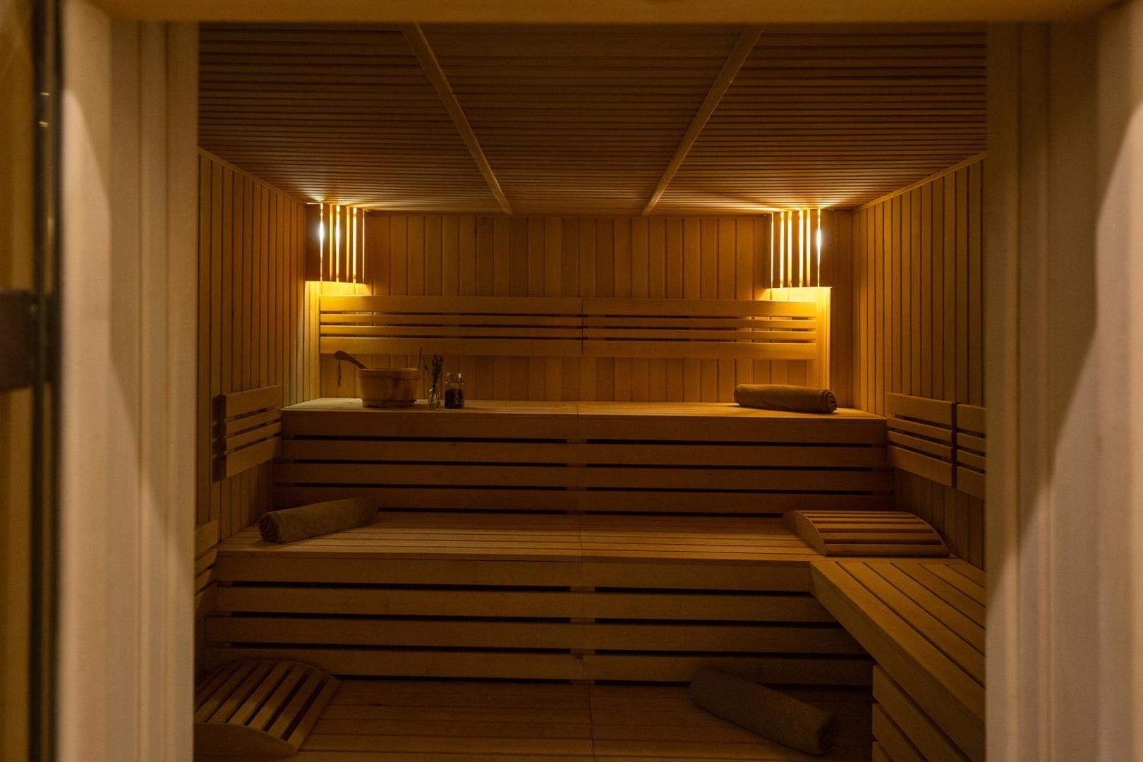 GRIFID Metropol Hotel spa centra sauna ar koka apdari un siltu apgaismojumu — relaksācijas zona viesiem Zelta Smiltīs, Bulgārijā