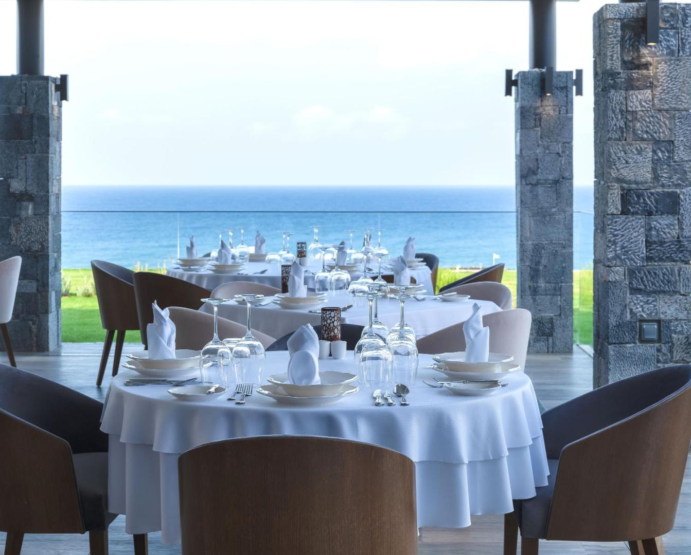 Nana Princess Suites Villas & Spa āra terases restorāns ar klātiem galdiem un panorāmas skatu uz zilo Vidusjūru Krētā