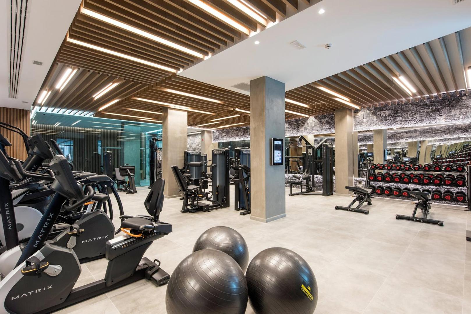 Nana Princess Suites Villas & Spa plašā fitness zāle ar Matrix trenažieriem, brīvajiem svariem un modernu apgaismojumu