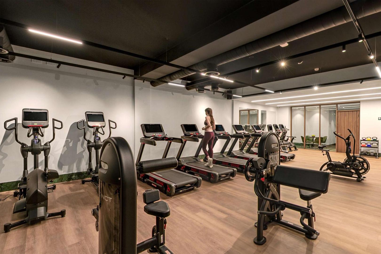 Cap St Georges Hotel & Resort moderns fitness centrs ar skrejceļiem un trenažieriem aktīvai atpūtai Kiprā