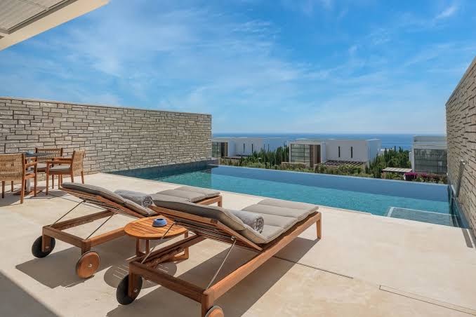 Cap St Georges Hotel & Resort numurs ar tiešu piekļuvi baseinam, sauļošanās krēsliem un skatu uz jūru Kipras piekrastē