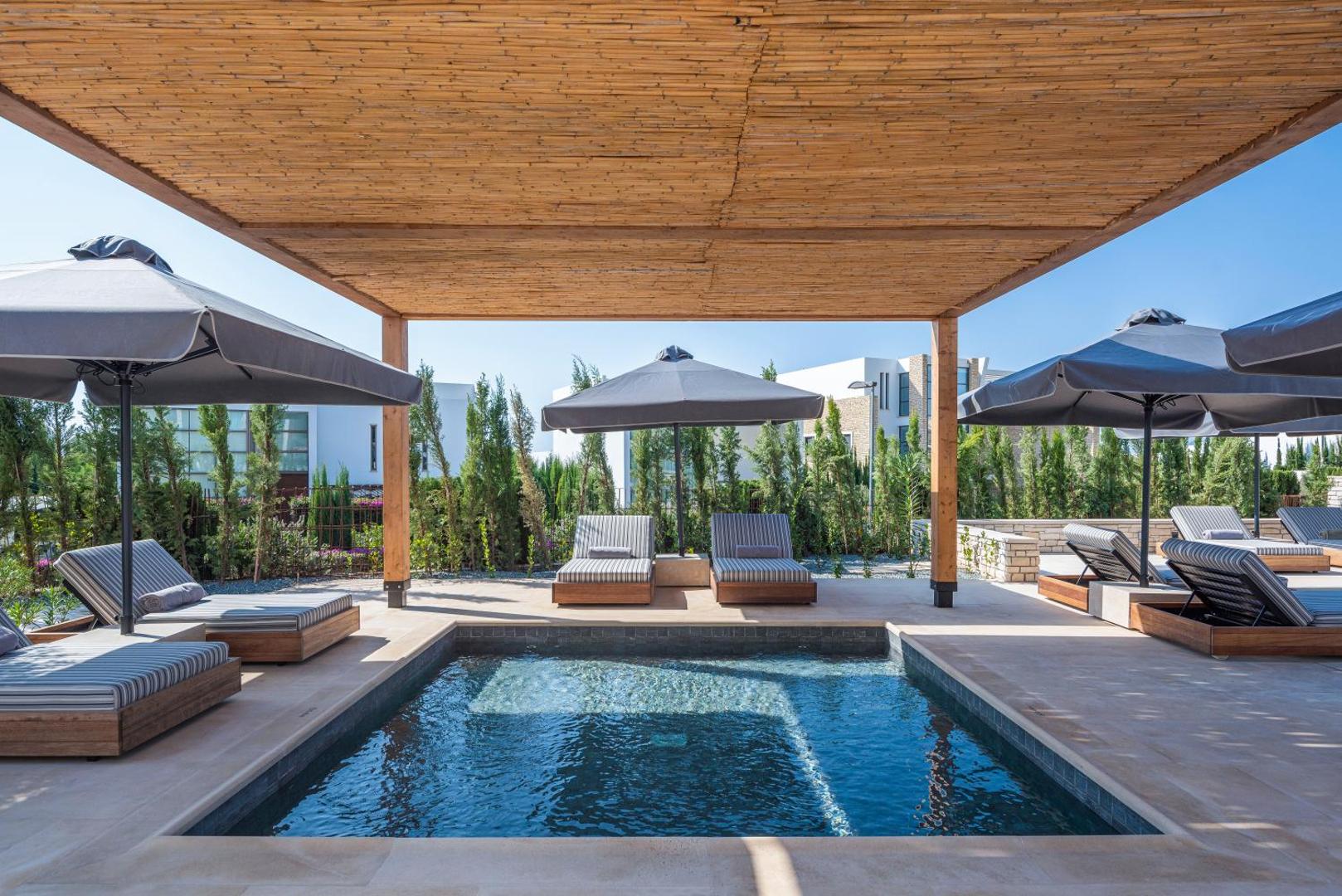 Cap St Georges Hotel & Resort privātais baseins zem koka nojumes ar ērtiem sauļošanās krēsliem un zaļojošu dārzu fonā