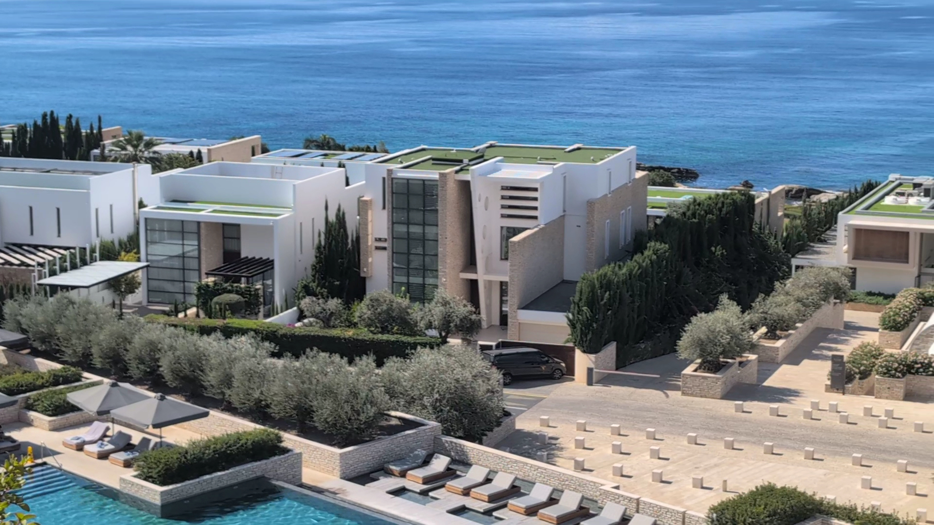 Cap St Georges Hotel & Resort modernās villas piekrastē ar zaļajiem jumtiem, baseina zonu un skatu uz zilo jūru