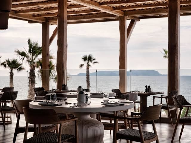 Stella Blue Seaside Resort ēdienkartes restorāns ar koka interjeru un skatu uz jūru un kalniem tālumā