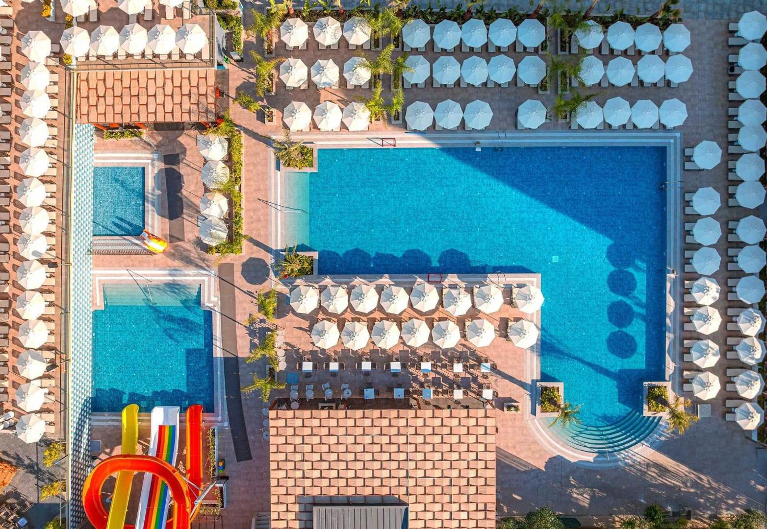 Vox Maris Resort baseinu kompleksa skats no augšas ar akvaparku, bērnu baseinu un daudziem saulessargiem