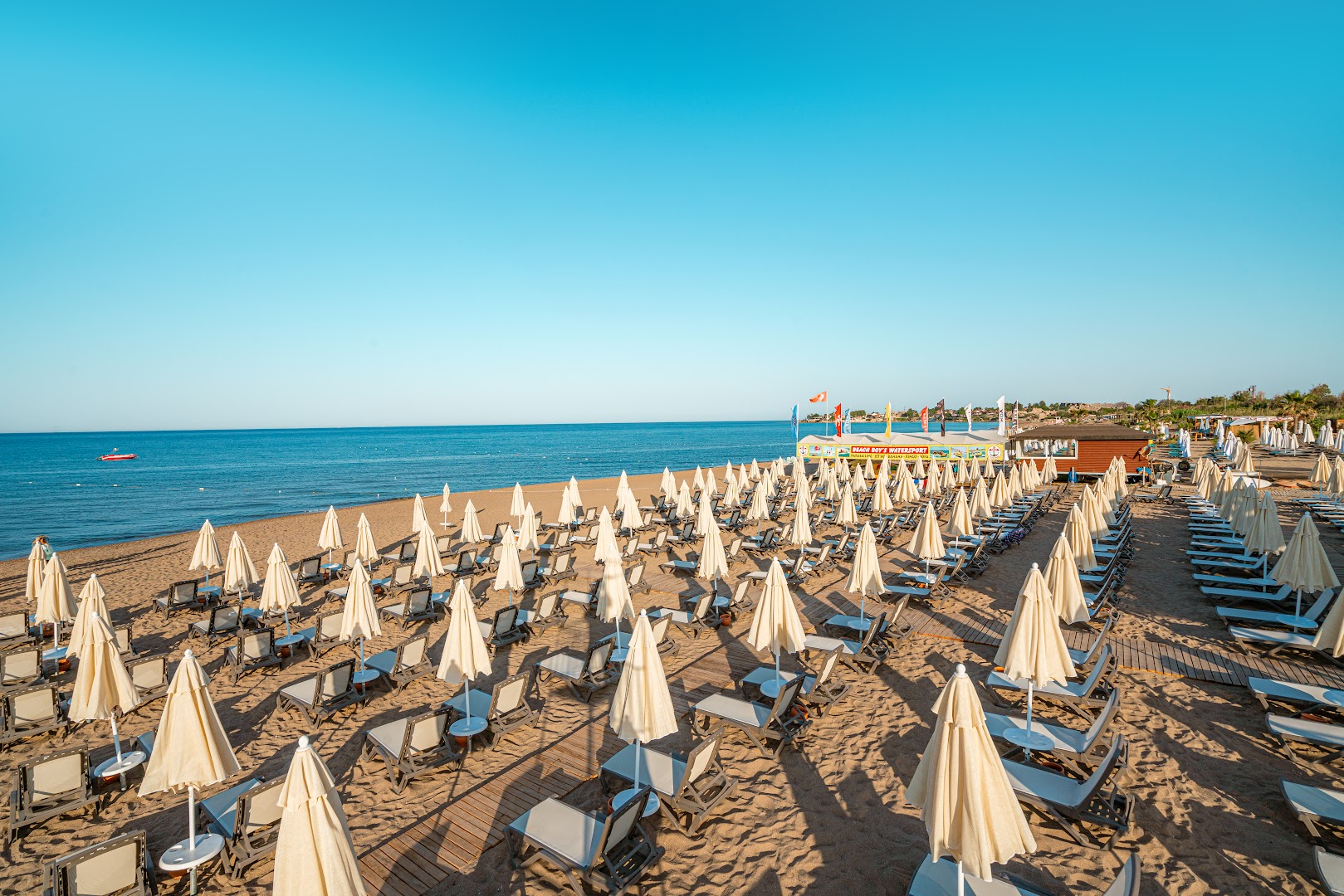 Vox Maris Resort privātā smilšu pludmale ar daudziem saulessargiem un sauļošanās krēsliem pie Vidusjūras Turcijā