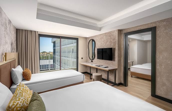 Vox Maris Resort ģimenes numurs ar atsevišķu guļamzonu, balkonu un skatu uz viesnīcas teritoriju Sides piekrastē