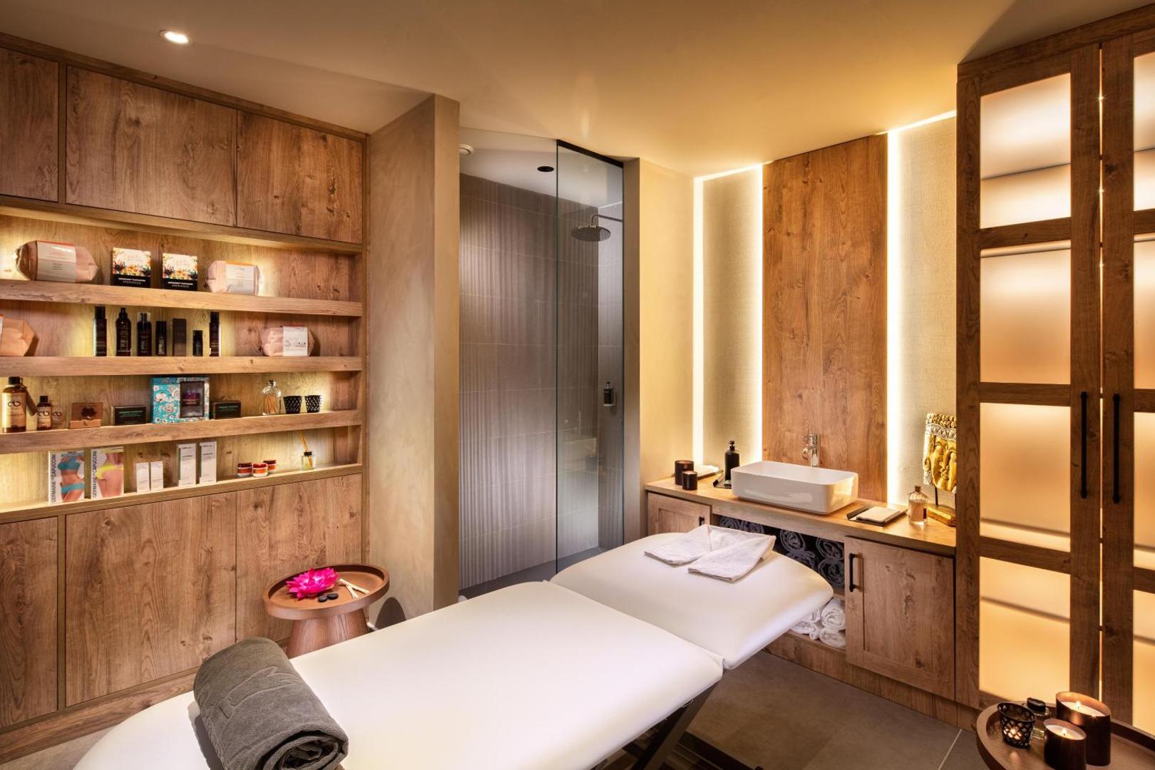 Guayarmina Princess spa procedūru numurs ar masāžas galdu, koka apdari un siltu apgaismojumu — mājīga atmosfēra relaksācijai