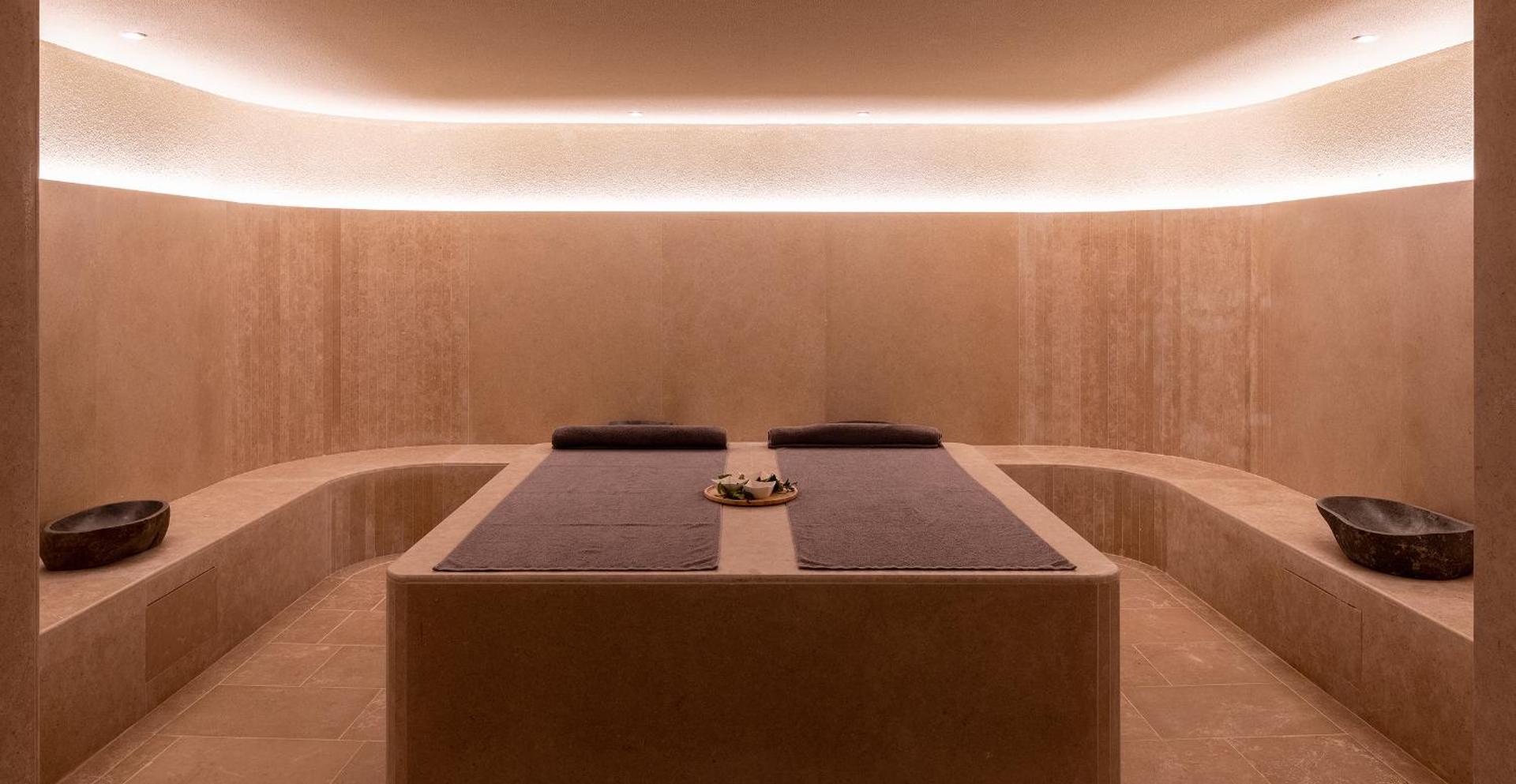 Helea Lifestyle Beach Resort spa centra hamama telpa ar akmens apdari, siltu apgaismojumu un masāžas galdiem