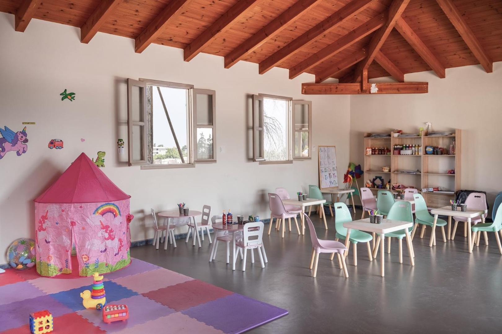 Helea Lifestyle Beach Resort bērnu kluba iekštelpas ar radošām darbnīcām, maziem galdiņiem un rotaļu telti