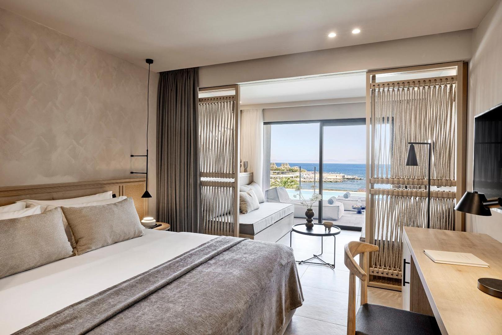 Helea Lifestyle Beach Resort moderns numurs ar skatu uz jūru Rodā — gaišs interjers, atpūtas zona un terase ar baseinu