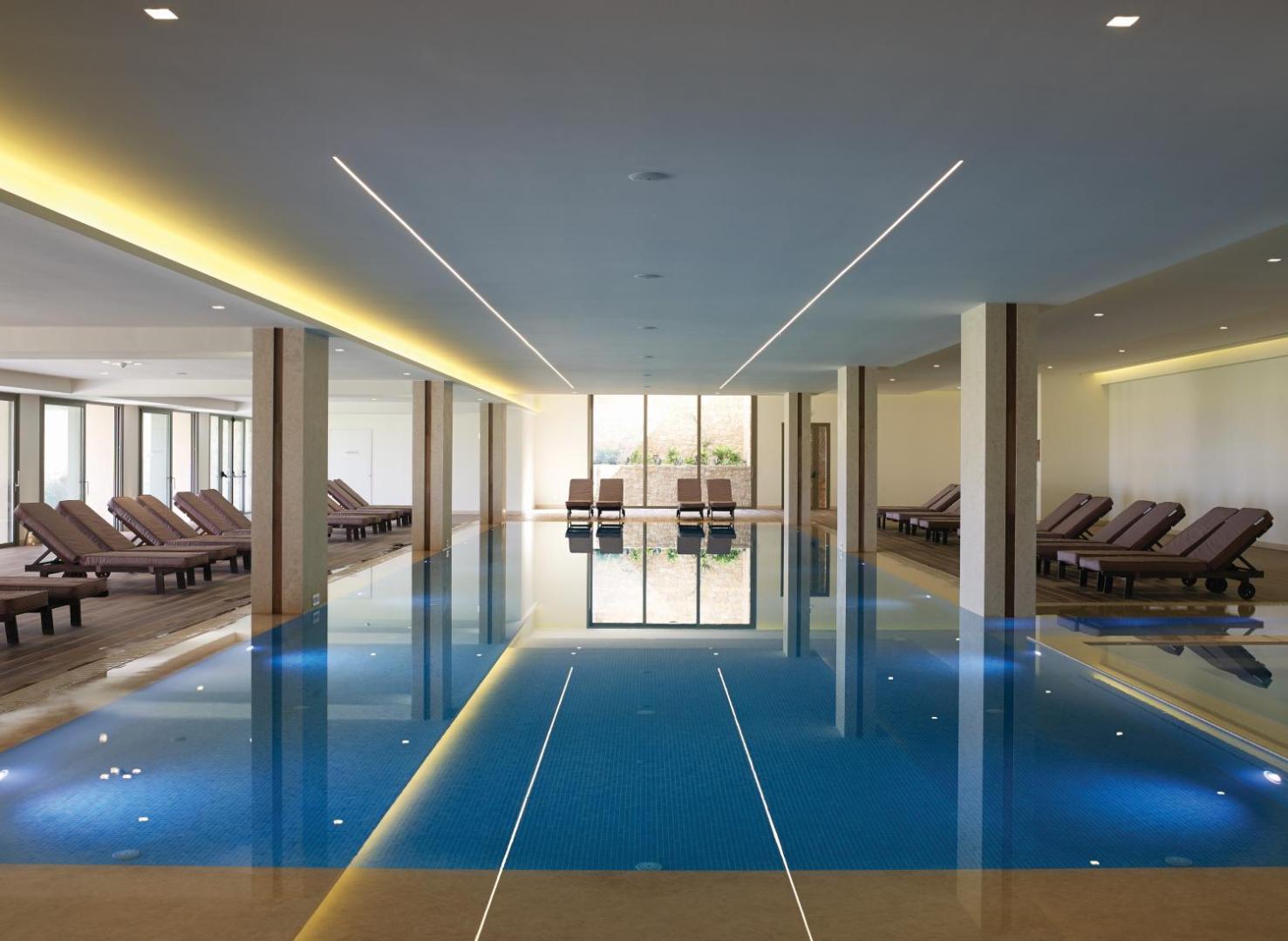 Atlantica Imperial Resort spa centra baseins ar modernu apgaismojumu un ērtiem zviļņiem — mierīga gaisotne atpūtai iekštelpās