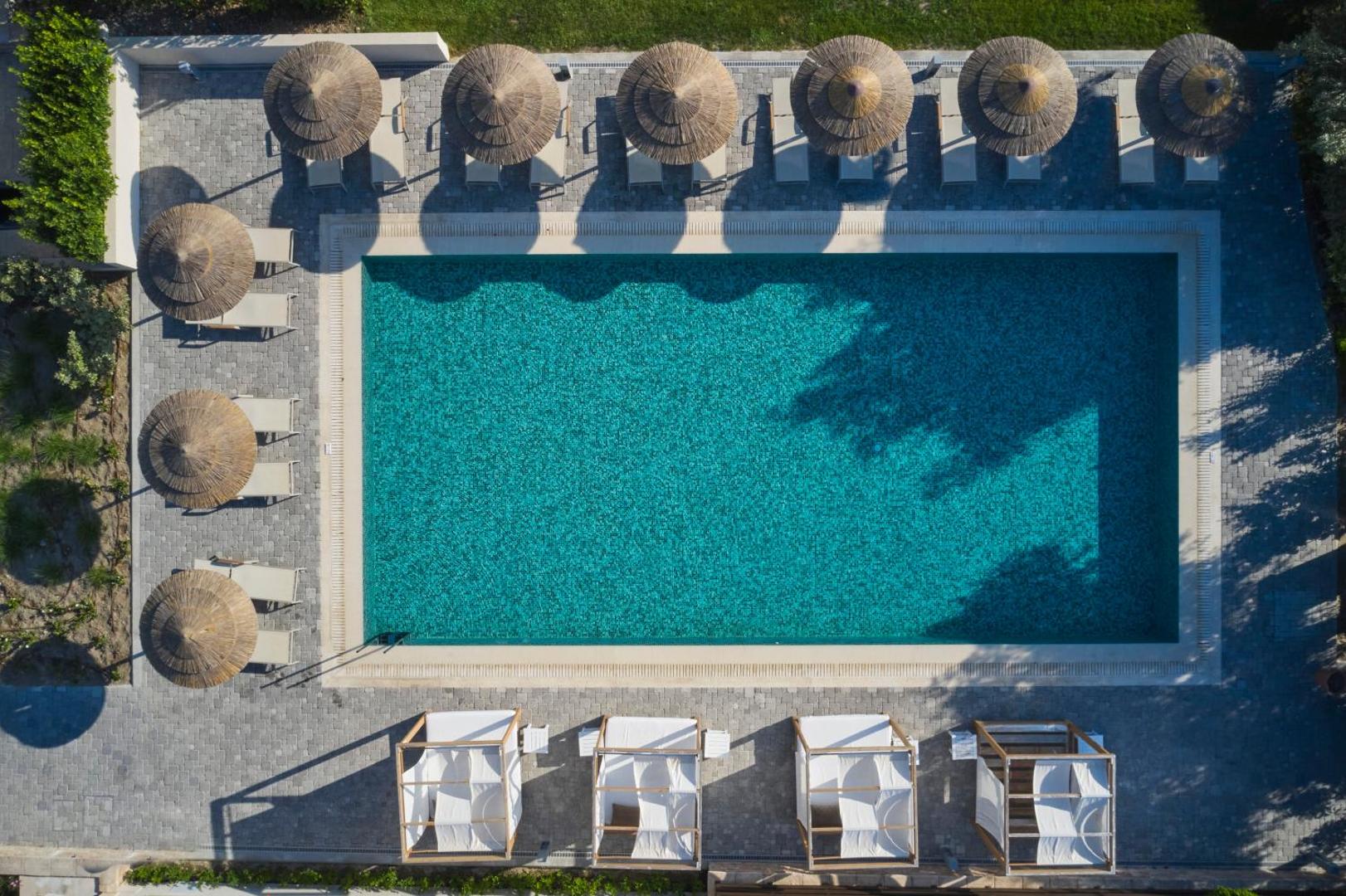 Atlantica Imperial Resort taisnstūra formas baseins no putna lidojuma ar salmu saulessargiem, zviļņiem un atpūtas gultām apkārt.