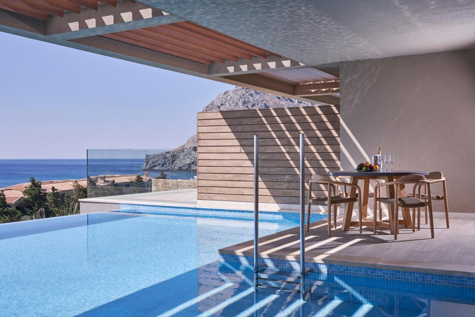 Atlantica Imperial Resort numurs ar privātu baseinu Rodas salā — skats uz jūru un kalniem no terases ar pusdienu galdu