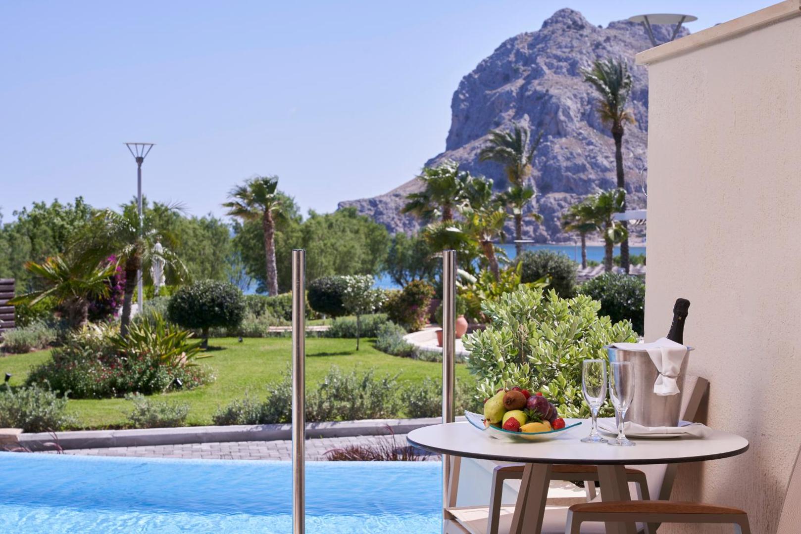 Atlantica Imperial Resort dārza skats no numura terases ar augļiem un dzērieniem pie baseina Rodas salā