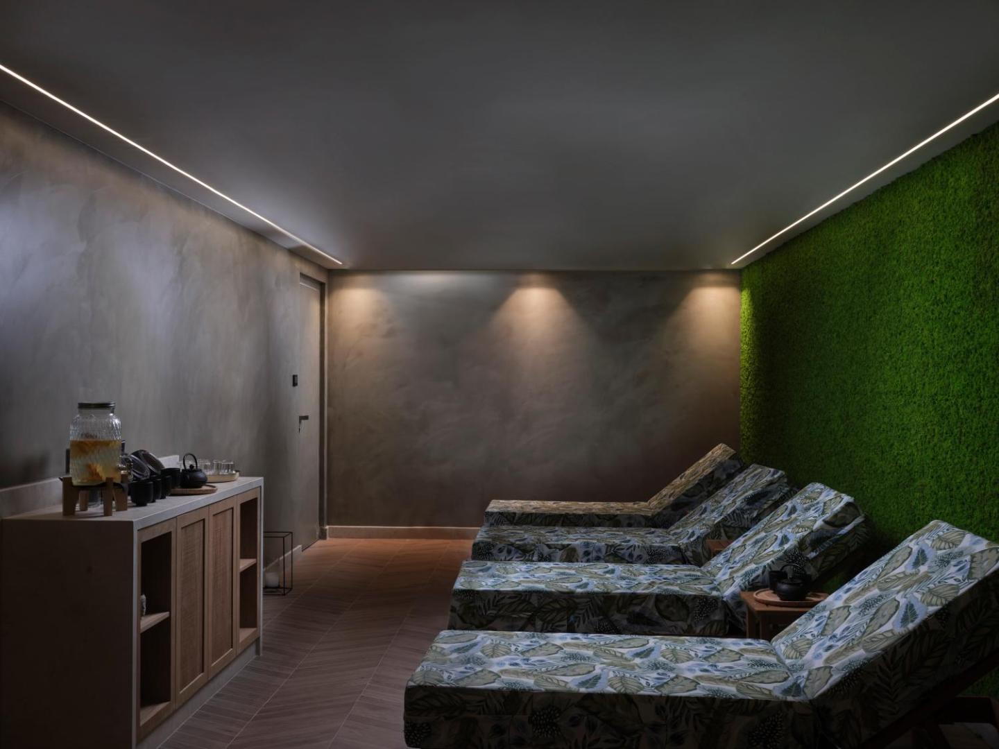Atlantica Aegean Blue spa atpūtas telpa ar mīkstiem zviļņiem, zaļo augu sienu un tējas stūrīti viesu atpūtai.