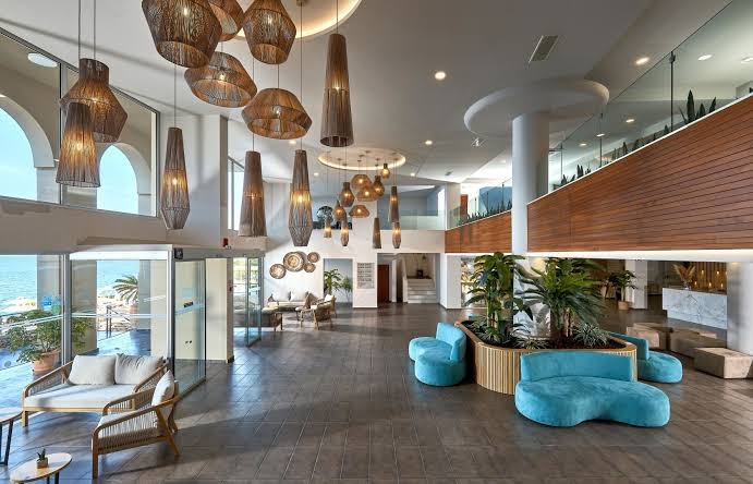 Blue Marine Resort & Spa lobby zona ar skatu uz jūru, stilīgām pītām lampām un ērtiem dīvāniem atpūtai