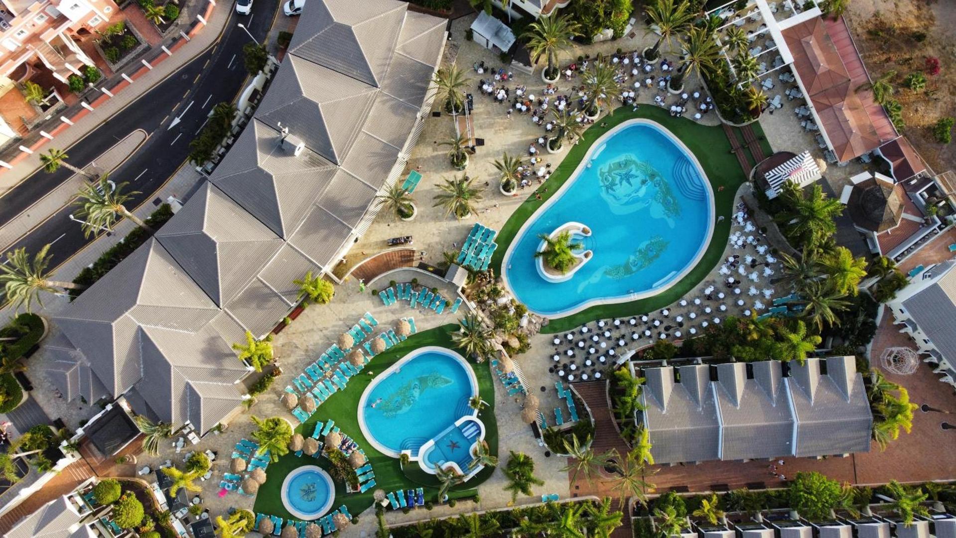Gran Oasis Resort skats no putna lidojuma uz viesnīcas baseiniem, atpūtas zonu un palmu dārzu Tenerifē, Kanāriju salās
