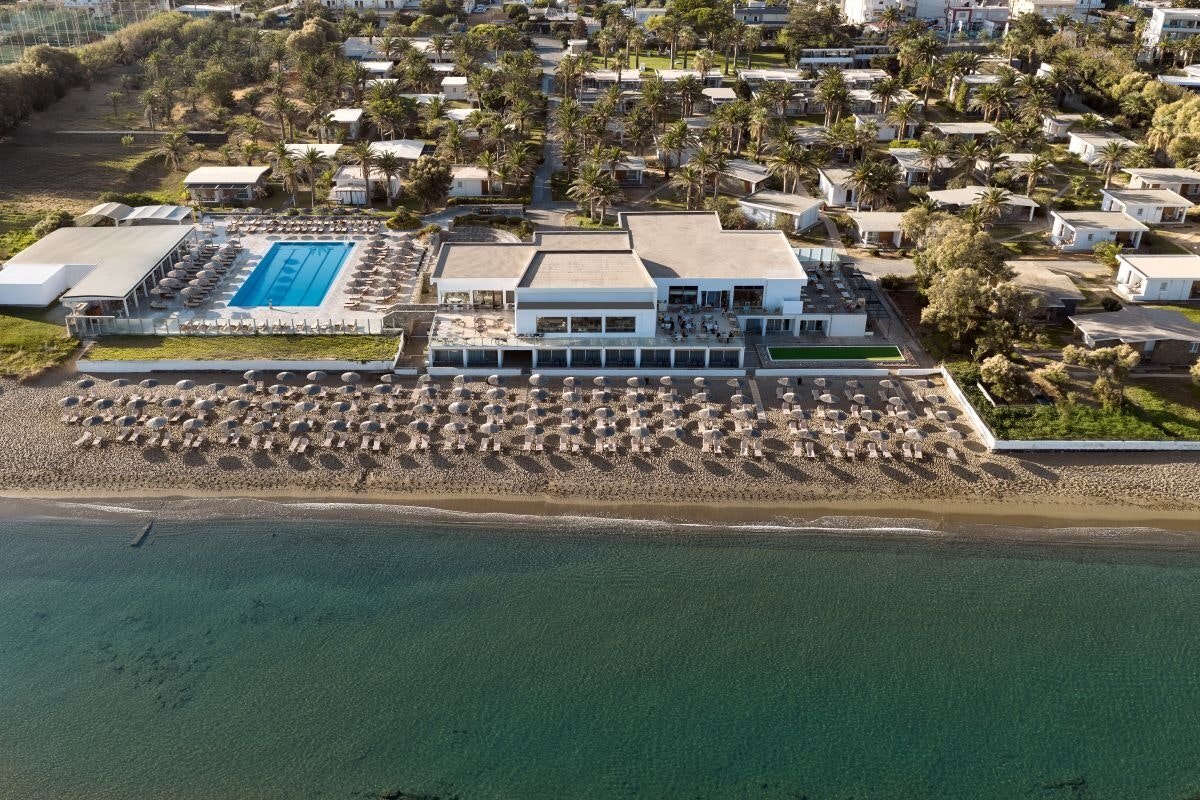 Civitel Creta Beach viesnīcas panorāmas skats no augšas Amudarā, Krētā — galvenā ēka, baseins un plaša smilšu pludmale ar saulessargiem