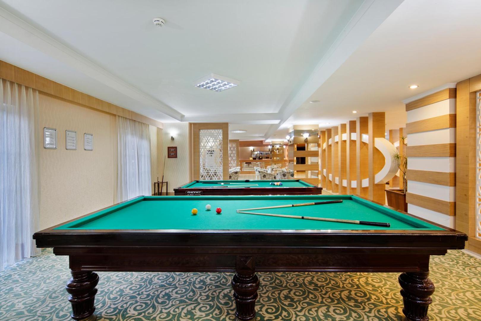 Sunis Elita Beach Resort biljarda zāle ar diviem galdiem un gaišu interjeru — atpūtas un izklaides zona viesnīcas iekštelpās