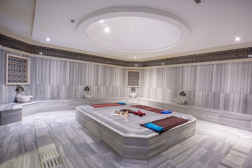 Pine Beach Belek tradicionālais turku hamams ar marmora apdari, centrālo akmens platformu un dekoratīvām flīzēm