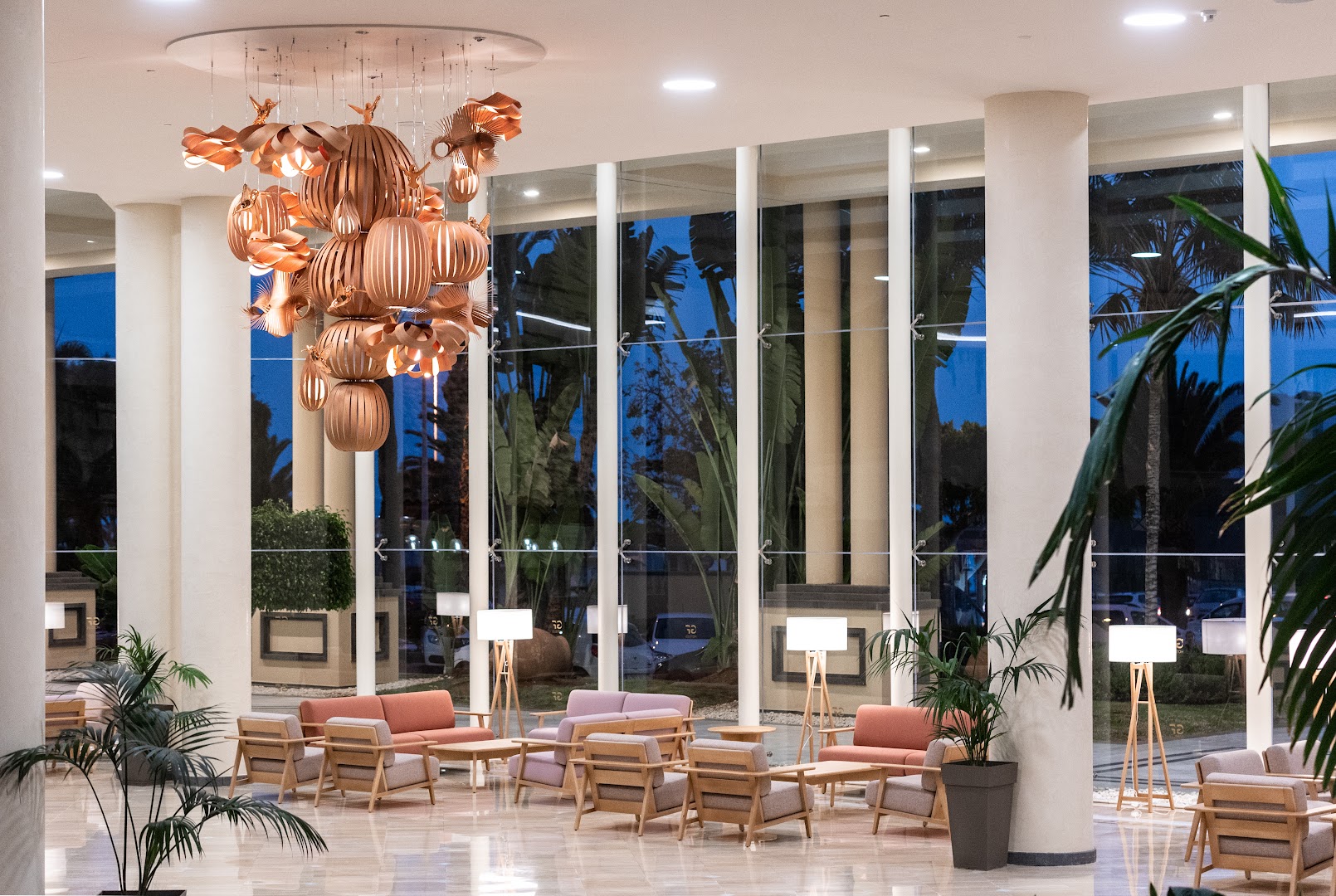 Viesnīcas GF Gran Costa Adeje modernā lobby atpūtas zona ar dizaina gaismekļiem un ērtiem dīvāniem pie lieliem logiem