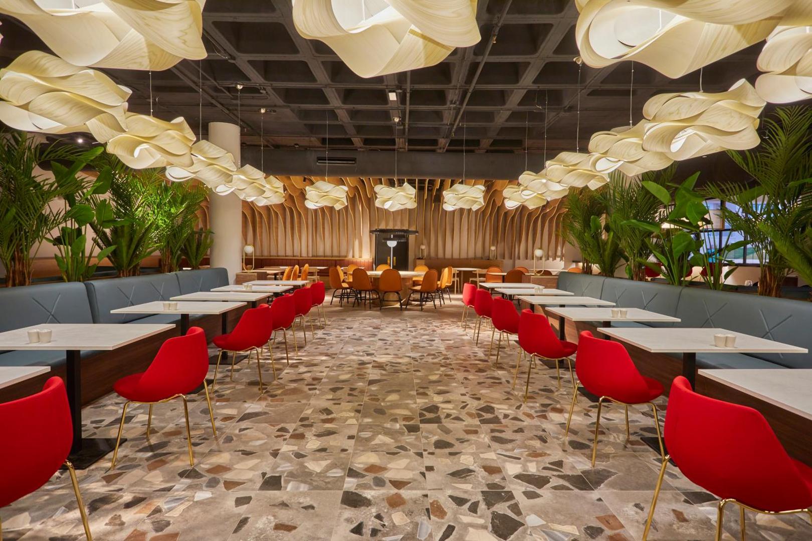 Bahia Principe Fantasia Tenerife dizaina restorāns ar unikāliem gaismas ķermeņiem, sarkanām mēbelēm un zaļiem telpaugiem.