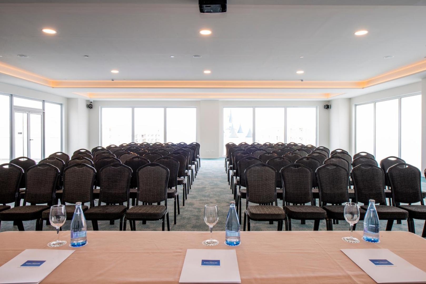 Plaša Bahia Principe Fantasia Tenerife konferenču zāle ar krēslu rindām un galdu prezentācijām Tenerifē