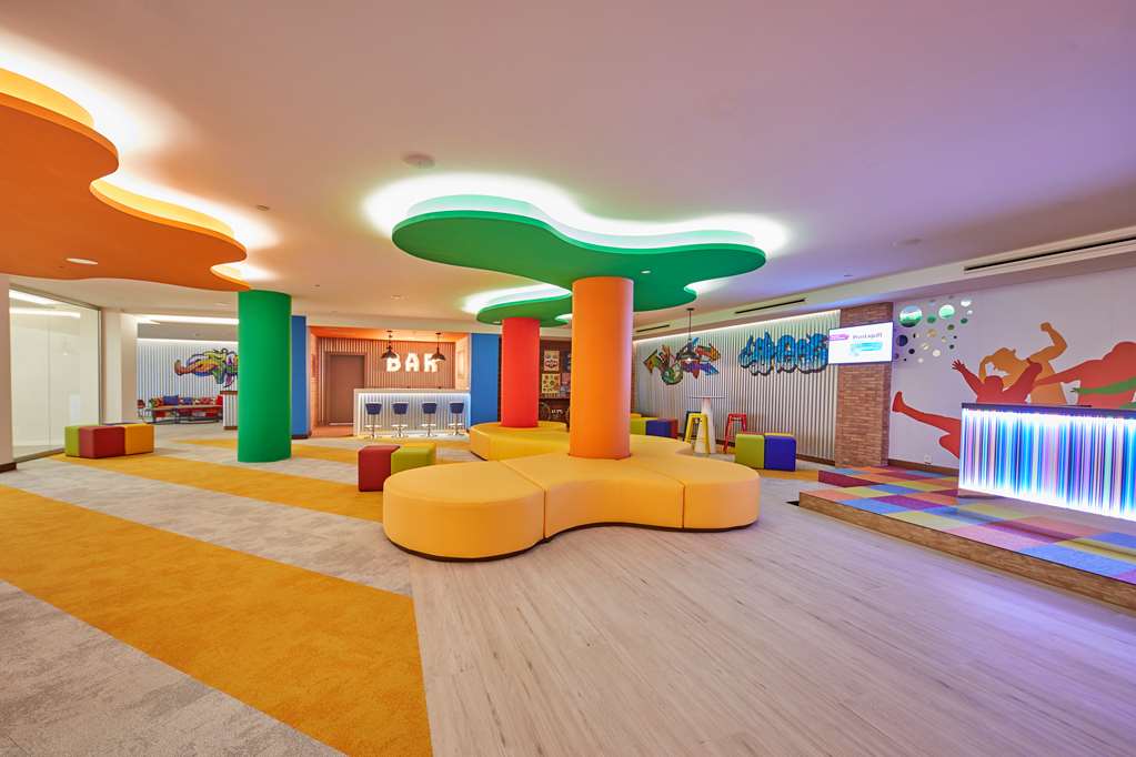 Bahia Principe Fantasia Tenerife krāsaina bērnu rotaļu istaba ar mīkstajām mēbelēm, spilgtām krāsām un bērnu bāru aktivitātēm.