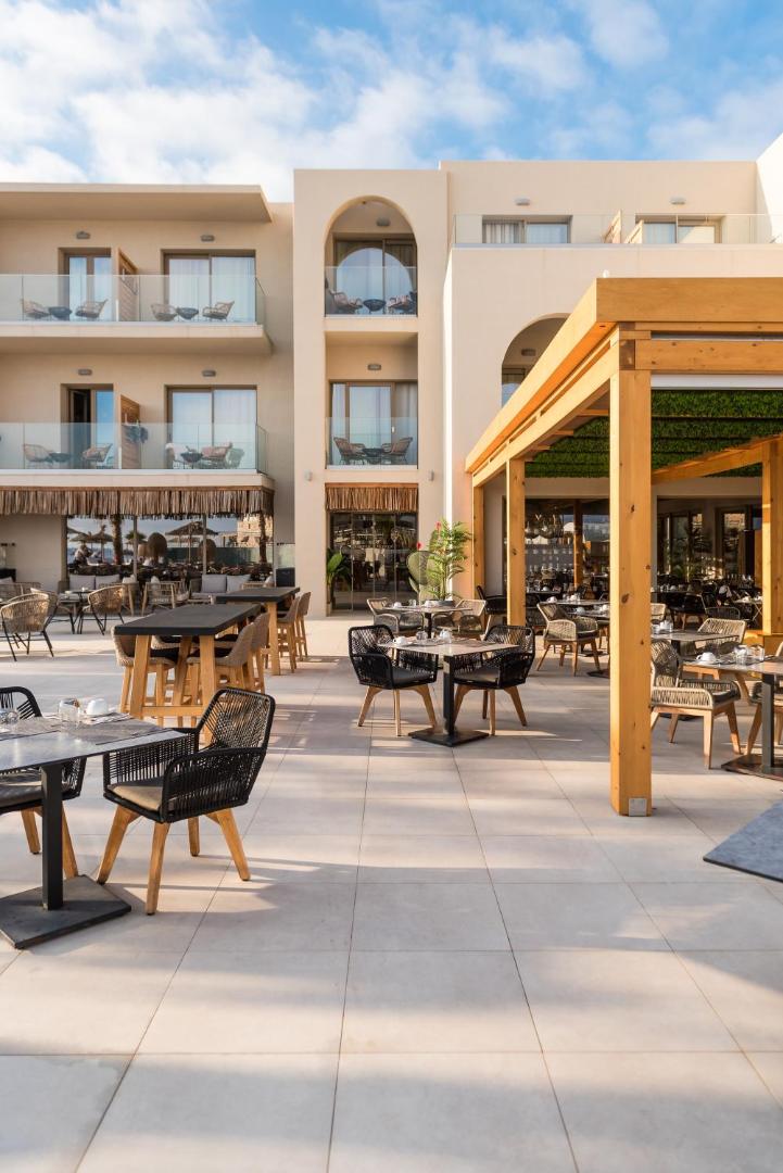 Pepper Sea Club viesnīcas fasāde ar balkoniem un āra restorāna zonu dienas gaismā — gaiša arhitektūra un moderns dizains