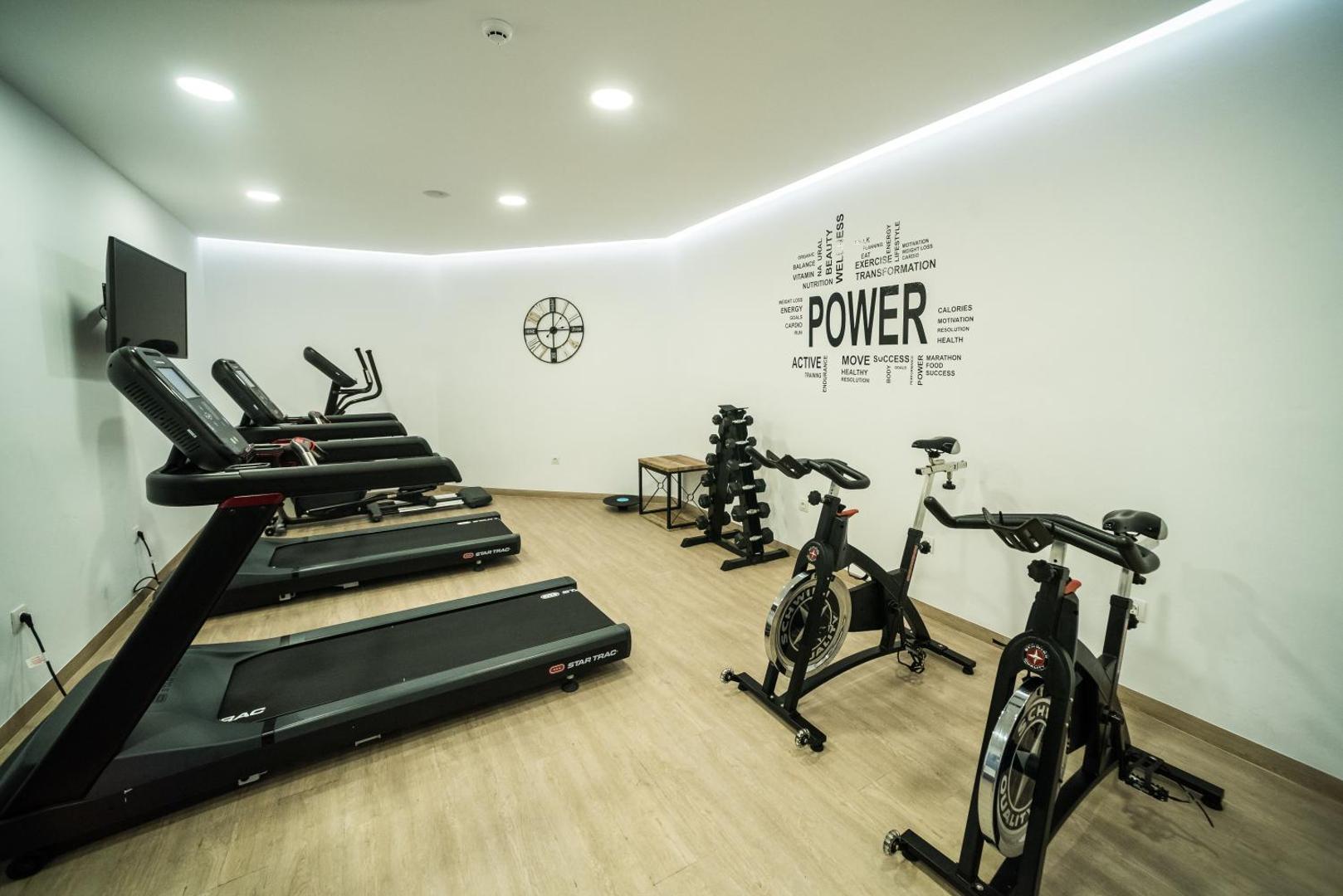 Mūsdienīga Pepper Sea Club fitnesa zāle ar skrejceļiem, velotrenažieriem un brīvajiem svariem gaišā interjerā