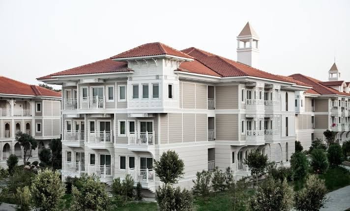 Ali Bey Resort Sorgun viesnīcas ēku komplekss ar gaišām fasādēm un balkoniem uz zaļojoša dārza fona