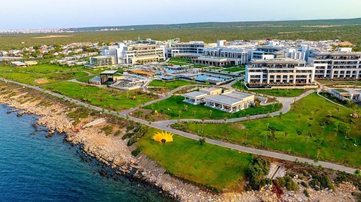 Anda Barut Collection viesnīcas teritorija no putna lidojuma — plaši zālieni, vairāki baseini un pieeja akmeņainai pludmalei Didimā