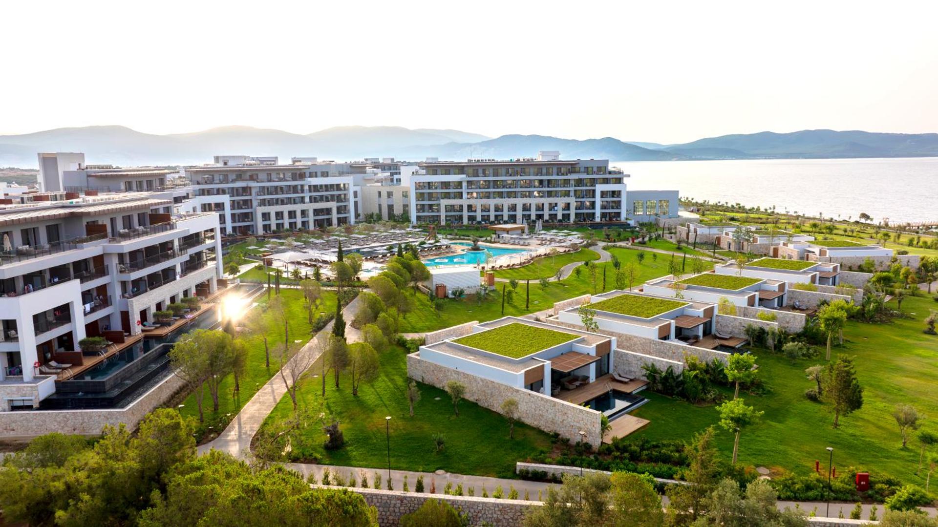 Anda Barut Collection modernie bungalo ar privātiem baseiniem un zaļajiem jumtiem — skats uz galveno baseinu un viesnīcas korpusiem