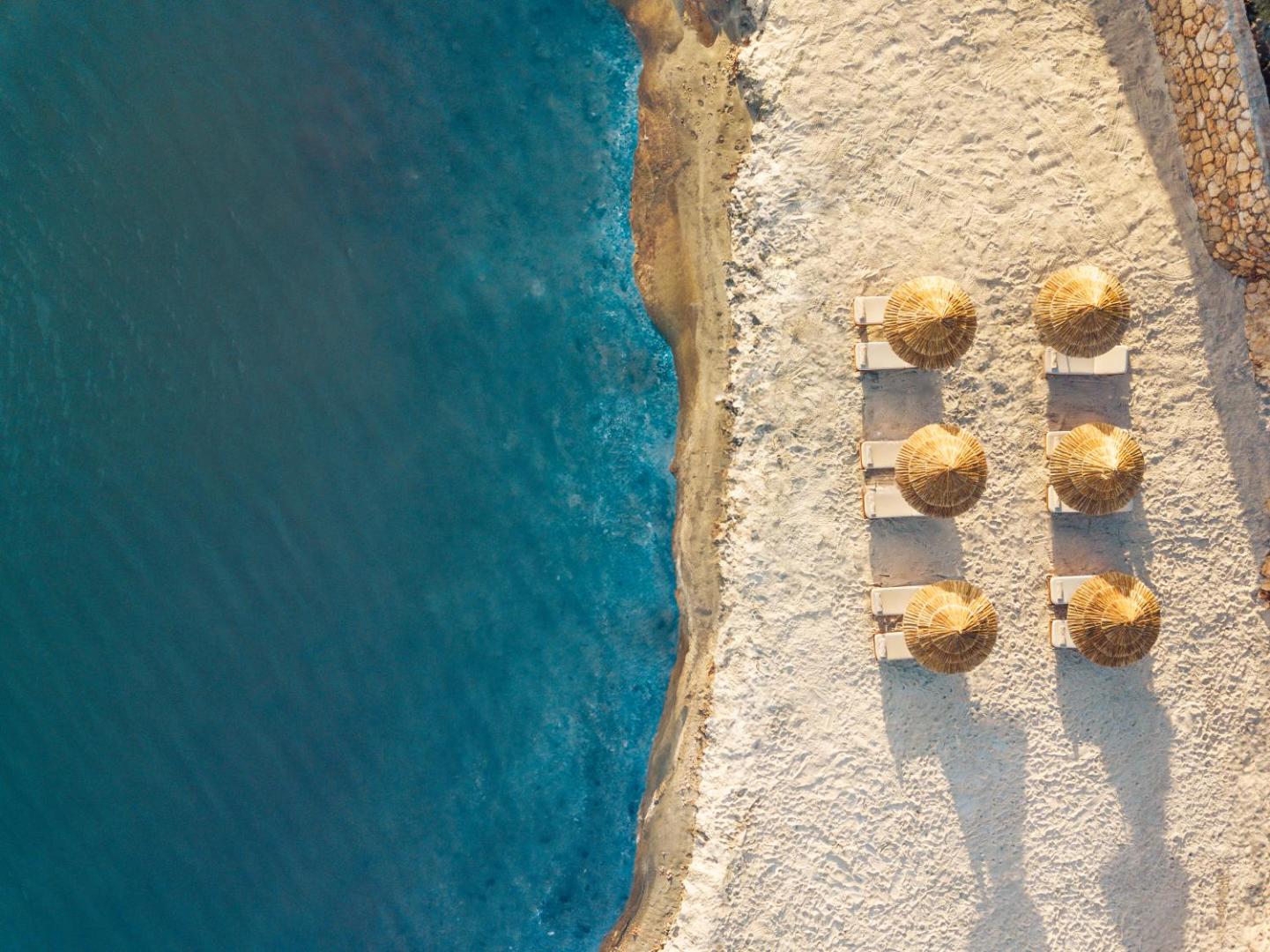 Anda Barut Collection skats no putna lidojuma uz privāto pludmali Didimā — gaišas smiltis, tirkīza ūdens un salmu saulessargi
