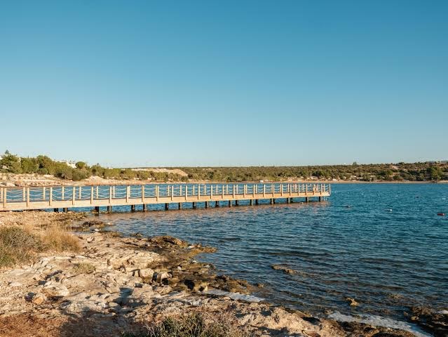Anda Barut Collection koka mols stiepjas dzidrā Egejas jūrā — akmeņaina piekraste un mierīgs ūdens pie Didimas
