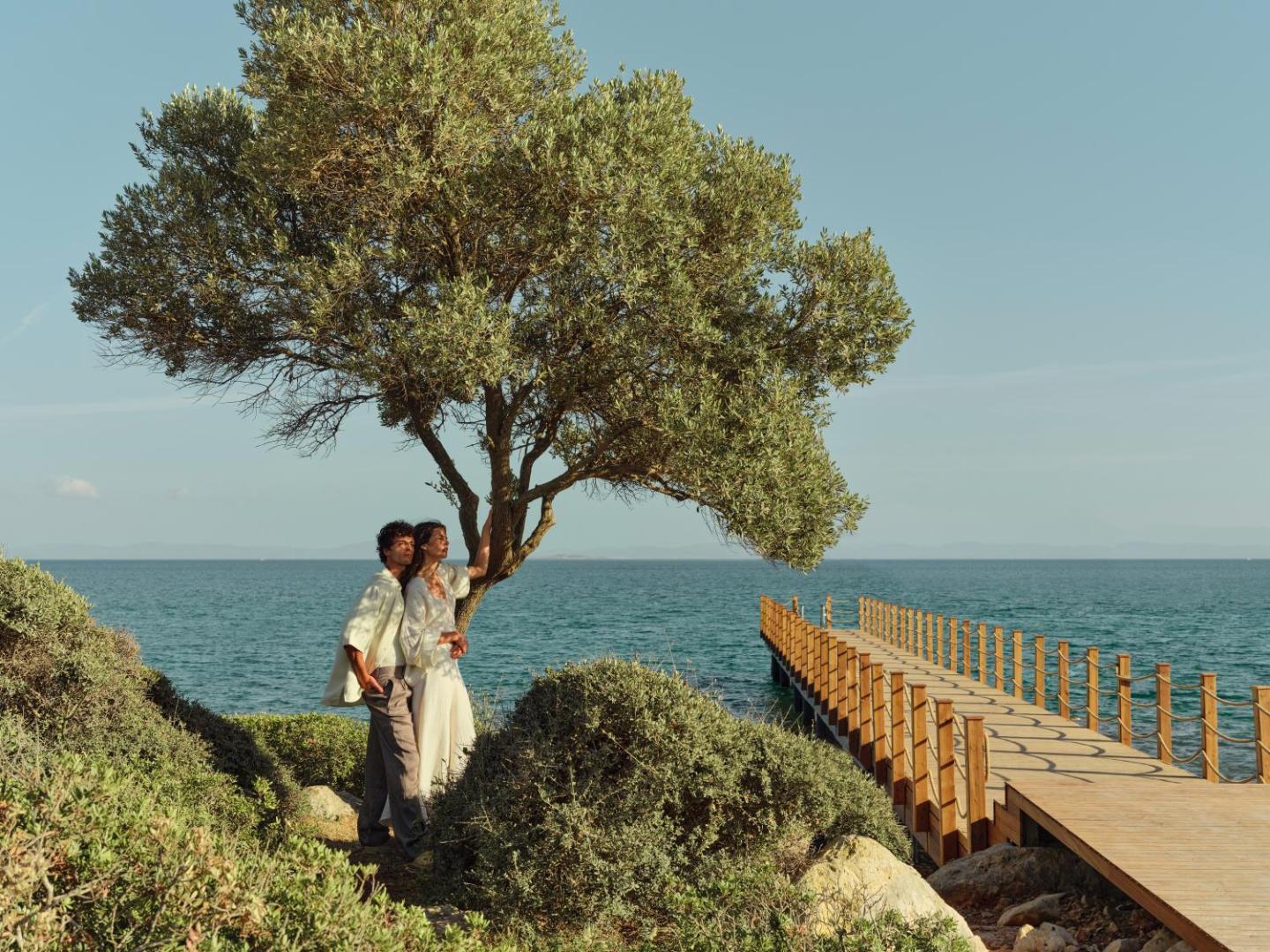 Anda Barut Collection viesnīcas koka laipa un pāris zem olīvkoka pie jūras Didimā — romantiska gaisotne un tirkīzzils ūdens