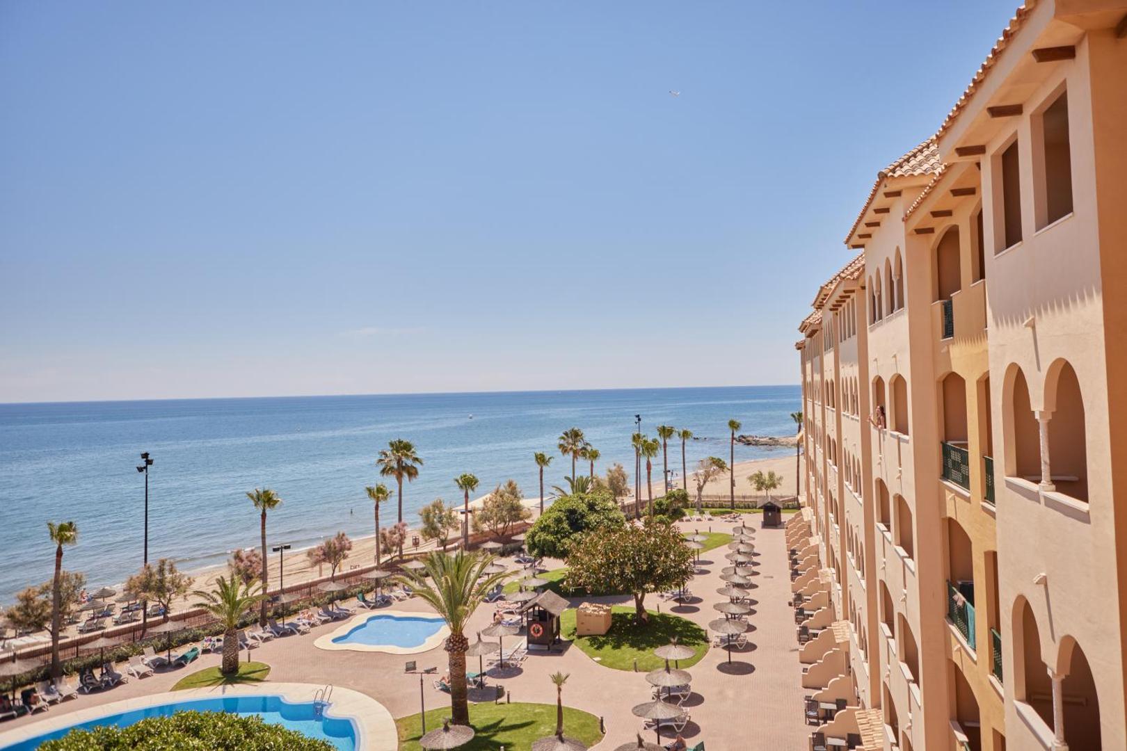 Skats no Hotel IPV Palace & Spa balkona uz iekšpagalmu ar baseiniem, palmām un tiešu izeju uz pludmali Costa del Sol