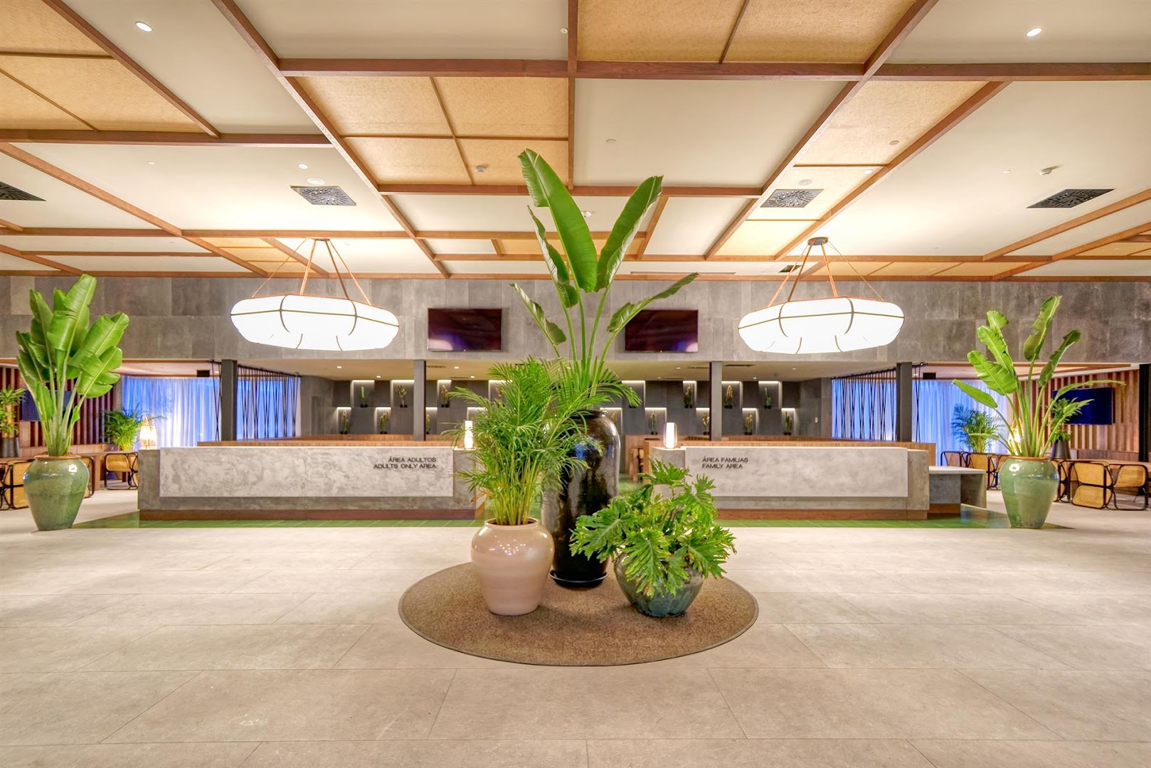 Hovima Suite Costa Adeje viesnīcas vestibils ar modernu recepcijas leti, lieliem telpaugiem un dizaina gaismekļiem