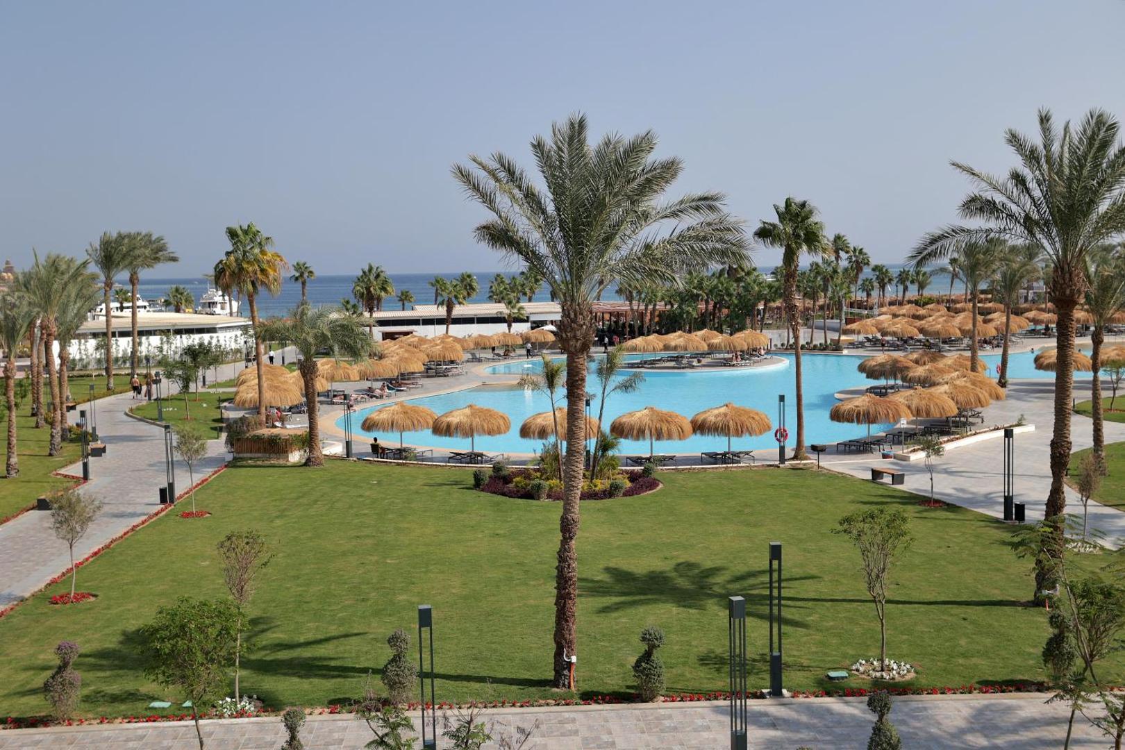 Xanadu Club Makadi Bay plašā teritorija ar lielu āra baseinu, koptu zālienu un palmām Makadibeja kūrortā pie Sarkanās jūras