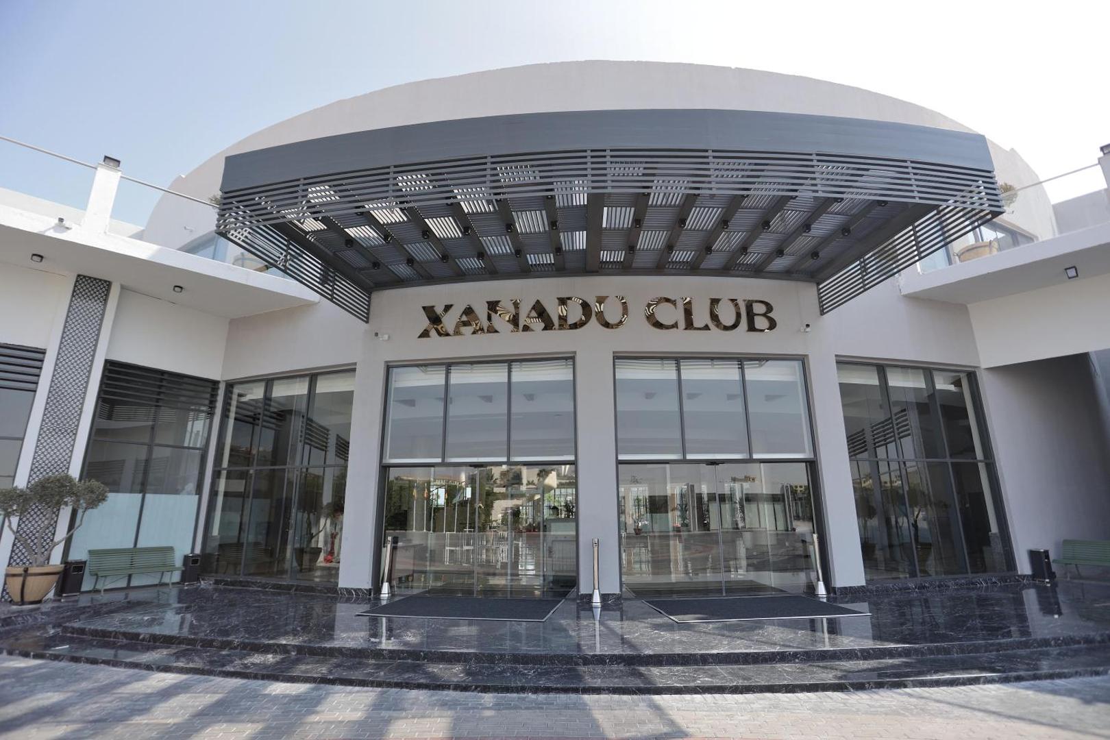 Xanadu Club Makadi Bay galvenā ieeja ar modernu stikla fasādi un tumša marmora kāpnēm Makadi līča kūrortā, Ēģiptē